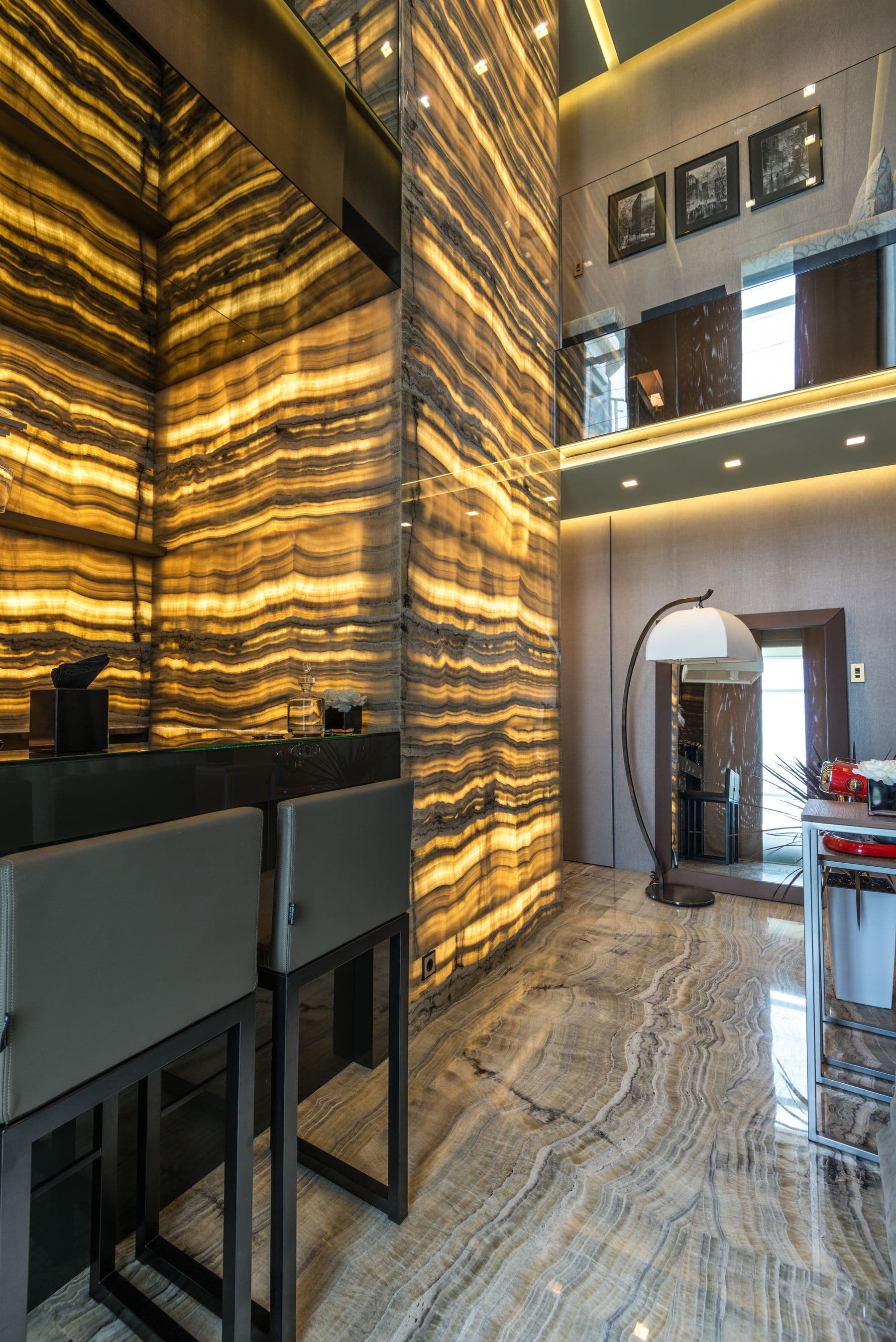 A warm showroom with a backlit onyx feature wall and marble floor