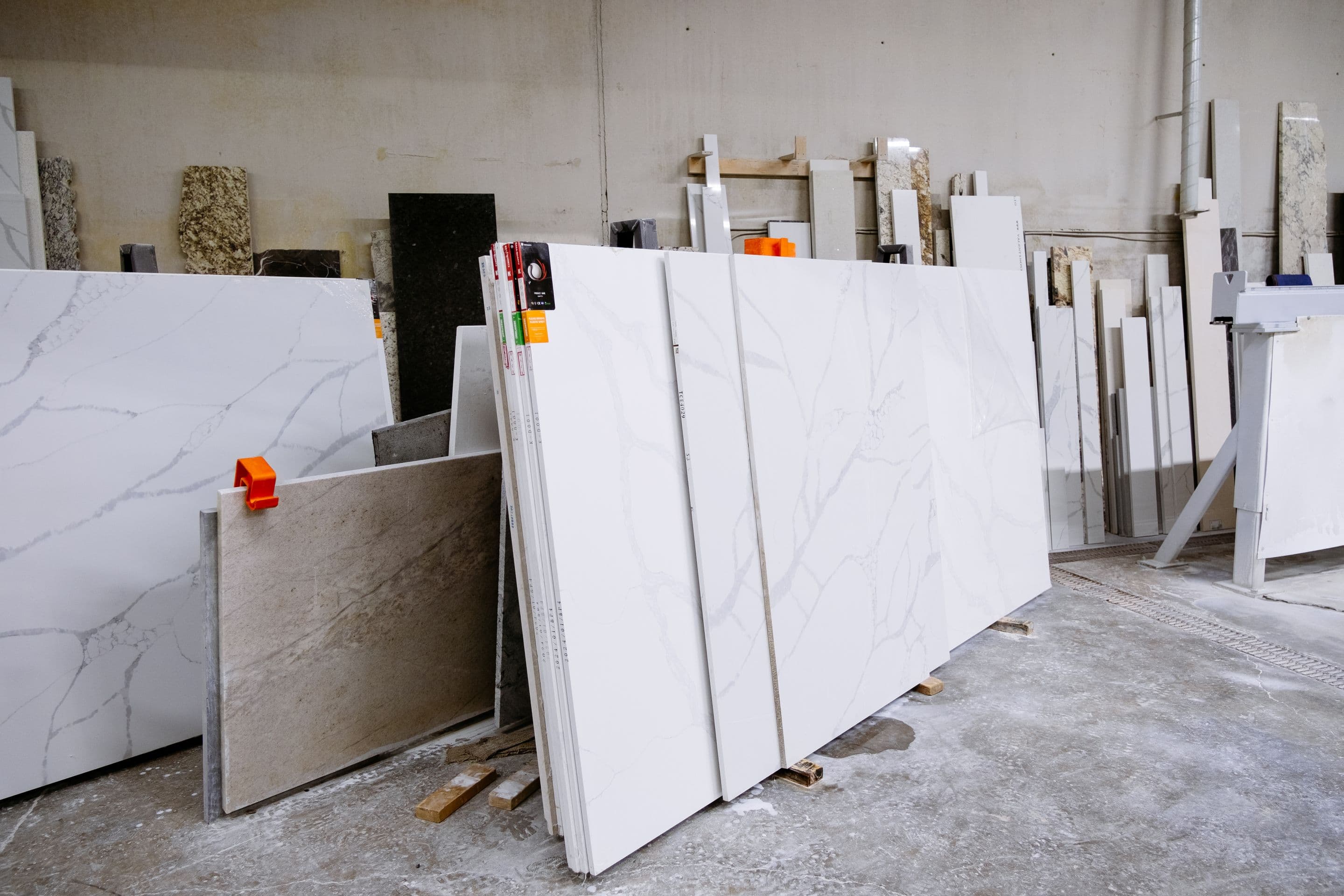 Rows of large finished stone slabs standing on racks inside a factory